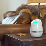 The pureAir 500 by Greentech resting on a coffee table next to a chair in the living room.
